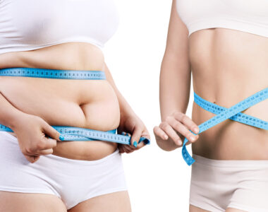 Two Women Holding Measuring Tape Around Their Torso To Show Weight Loss